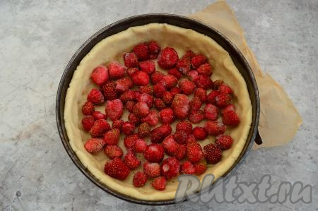 На дно формы с тестом выложить клубнику в один слой.