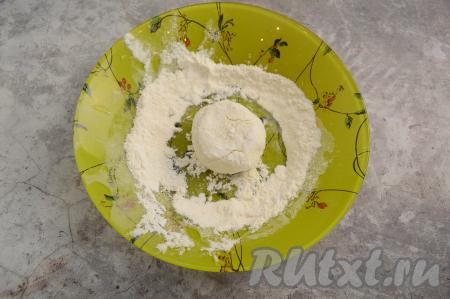 На отдельную тарелку насыпать 2 столовых ложки муки. Зрительно разделить творожное тесто на равные части (я разделила на 7 равных частей). Влажными руками сформировать округлую заготовку сырника из одной части теста и обвалять со всех сторон в муке.
