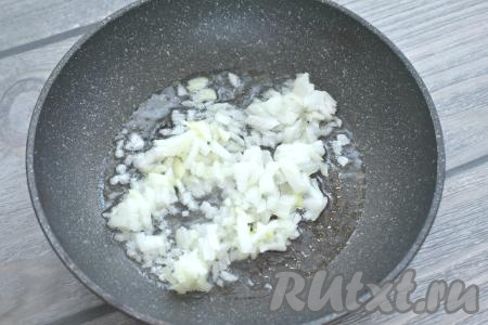 Очищаем и мелко нарезаем луковицу. Разогреваем на сковороде растительное масло, выкладываем лук и обжариваем его на среднем огне до мягкости (ориентировочно в течение 3-4 минут), периодически помешивая. Затем, убрав с огня, даём луку немного остыть.