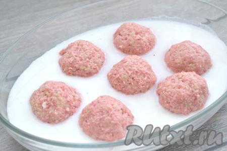 Сметану смешиваем с 400 миллилитрами тёплой кипячёной водой, солим, перчим по вкусу и выливаем получившийся сметанный соус в форму с тефтелями. Соус должен покрыть тефтели наполовину.