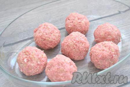 Слегка смачиваем ладони водой и формируем из фарша круглые тефтели (у меня получилось 7 штук), выкладываем их в форму для запекания.