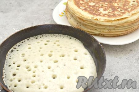 Поверхность сковороды смазываем растительным маслом, хорошо разогреваем. Выливаем половник дрожжевого блинного теста на разогретую сковороду, равномерно распределяя по всему дну сковородки. Выпекаем блинчик на среднем огне до подрумянивания с двух сторон (примерно по 1 минуте с каждой стороны), затем перекладываем пышный блин на тарелку. Постепенно жарим все блинчики из оставшегося теста, замешанного на живых дрожжах и молоке. Тесто в миске не забывайте периодически перемешивать. Я готовила блины на сковороде диаметром 17 сантиметров, у меня получилось 16 нежных блинчиков. Поверхность сковороды перед жаркой очередного блина смазывайте только по мере необходимости, то есть если блинчики начнут прилипать к поверхности.