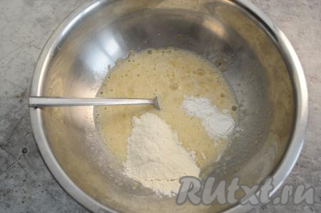 В миску с бананово-яичной массой всыпать разрыхлитель и половину муки, перемешать до однородности.