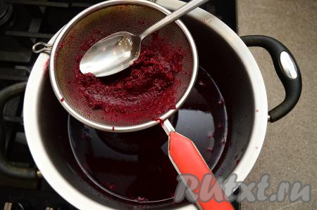 Получившийся компот из чёрной смородины убрать с огня, дать ему остыть хотя бы в течение минут 10. Затем процедить компот через сито. Оставшиеся в сите ягоды смородины перетереть через сито в кастрюлю с компотом. Останется небольшое количество жмыха в сите. Жмых мы выбрасываем.