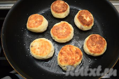 Затем аккуратно перевернуть сырники и обжаривать ещё 2-3 минуты (до подрумянивания с другой стороны). В конце жарки выключить огонь, ещё раз перевернуть сырники, накрыть их крышкой и дать им пропариться в сковороде в течение 5-6 минут.