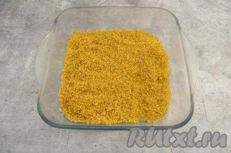 В форму для запекания выложить булгур, разровнять его, посолить (я добавила 0,5 чайной ложки соли). 