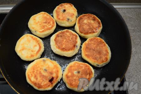 Эти сырники нужно хорошо прожаривать, чтобы замороженные ягоды успели хорошо прогреться, поэтому уменьшить огонь до ниже среднего, перевернуть сырники, уже обжаренные с двух сторон, и томить их под крышкой 2-3 минуты, снова перевернуть и готовить ещё 2-3 минуты под крышкой.