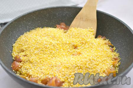 Затем всыпаем к овощам кукурузную крупу.