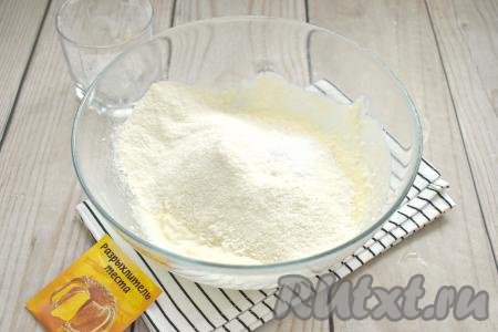 В получившуюся творожную массу просеиваем 3/4 стакана муки, добавляем разрыхлитель, перемешиваем тесто вначале столовой ложкой. А затем продолжаем замешивать творожное тесто руками, подсыпая по мере необходимости оставшуюся муку. 