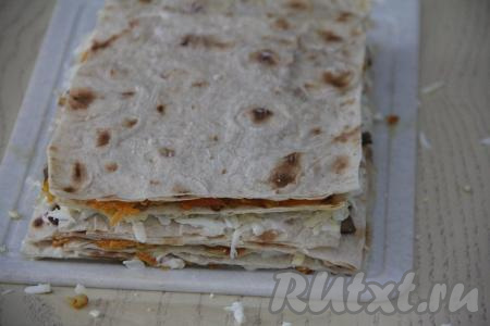 Продолжать собирать закусочный торт, для этого выложить четвёртый лист лаваша, смазать оставшейся овощной начинкой, разместить пятый лист лаваша, смазать майонезом, разложить оставшиеся грибы. Выложить шестой лист лаваша.