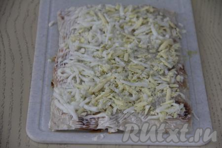 Накрыть третьим листом лаваша, смазать майонезом. Яйца натереть на крупной тёрке. Равномерно выложить половину натёртых яиц&nbsp;на лаваш.