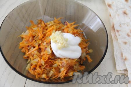 Очищенные зубчики чеснока пропустить через пресс и вместе с 1-2 столовыми ложками майонеза добавить к остывшим жареным моркови и луку.