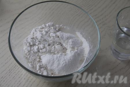 Для того чтобы замесить тесто для мантов, нужно соединить в миске 200 грамм муки и соль, перемешать столовой ложкой, затем влить холодную воду. Перемешивать тесто вначале столовой ложкой, а затем продолжить замешивать руками, подсыпая по мере необходимости муку.