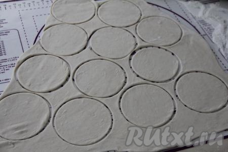 Тесто на посыпанной мукой поверхности раскатать скалкой в пласт толщиной примерно 2 миллиметра, с помощью формы (или кружки) вырезать кружочки диаметром 10 сантиметров. Остатки теста снова вымесить, раскатать, вырезать кружочки.