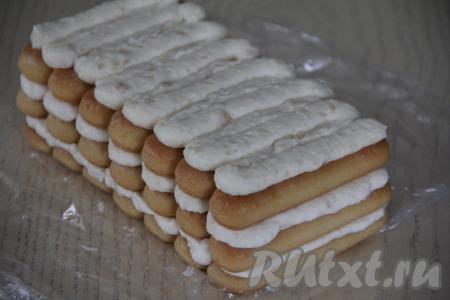 После нескольких часов пропитки в холодильнике я достала тирамису "Рафаэлло" из формы с помощью пищевой плёнки, которой была застелена форма, и переложила десерт на тарелку.