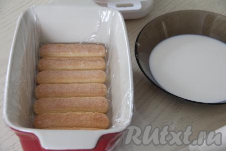 Выложить несколько пропитанных печений "Савоярди" (я выложила 7 штук) в один слой в подходящую форму. Я формировала торт в керамической форме, предварительно застелив дно и бока формы пищевой плёнкой.