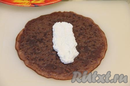 В центр каждого шоколадного блина выложить 2-3 чайных ложки творожной начинки.