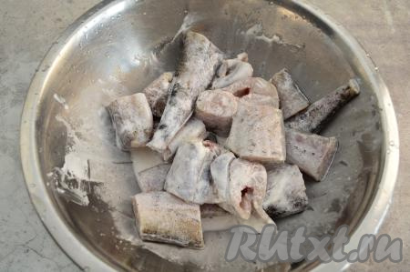 Сложить кусочки минтая в миску, посолить, добавить 50 грамм сметаны, перемешать, накрыть крышкой и отправить рыбу в холодильник минут на 30.