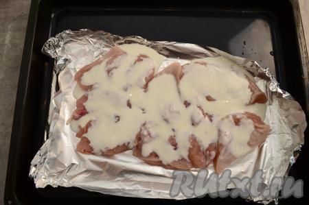 Сверху филе пролить немного кефиром. Можно вместо кефира смазать мясо майонезом или сметаной.