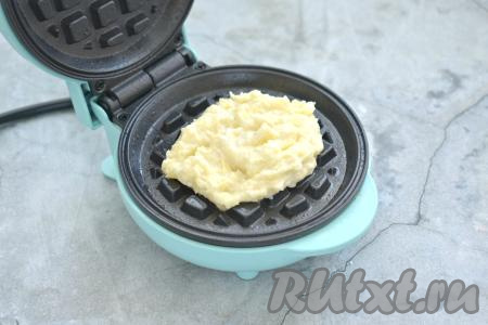 Включаем вафельницу. Панели вафельницы с помощью силиконовой кисточки смазываем растительным маслом (я смазывала панели маслом только перед жаркой первой вафли). В центр нижней панели выкладываем 2 столовых ложки картофельно-сырного теста.