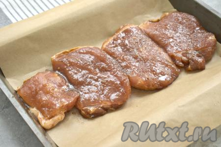 Форму для запекания застилаем пергаментом (или пищевой фольгой), затем выкладываем промариновавшиеся кусочки мяса и отправляем в хорошо прогревшуюся духовку.