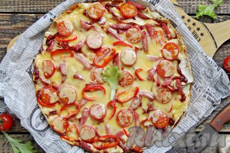 Горячую пиццу из рваного лаваша переложить со сковороды на плоскую тарелку или доску и сразу же подать к столу.