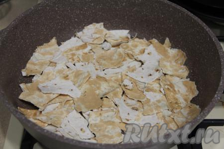 В отдельно миске соединить яйца и молоко, посолить и взболтать вилкой. В сковороду влить немного растительного масла, затем выложить рваный лаваш и поставить на минимальный огонь. Я использовала сковороду диаметром 28 сантиметров.