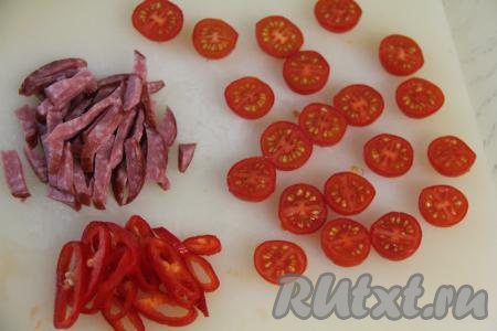 Болгарский перец вымыть, очистить от плодоножки и семян. Половину перца нарезать на тонкие полоски или колечки. Колбасу нарезать на небольшие брусочки.&nbsp;Помидоры черри разрезать пополам. Если у вас обычные помидоры, тогда нарежьте их на полукружочки.