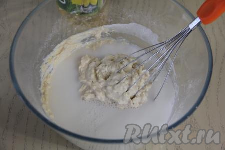 В получившееся густое, вязкое тесто влить 200 миллилитров молока, перемешать венчиком до однородности.