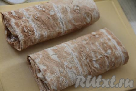 Подвернуть вначале боковые края лаваша на начинку, а затем свернуть шаурму в плотный рулет, начиная со стороны с начинкой. Из второй части лаваша и оставшейся начинки сформировать ещё одну шаурму с тунцом.