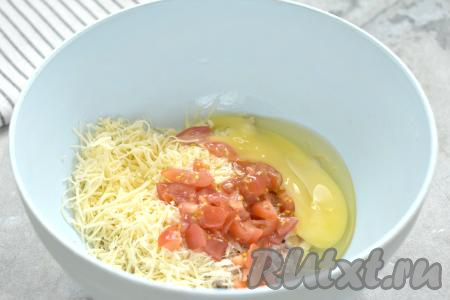 Помидор моем, нарезаем мелко, перекладываем в миску с курицей и сыром, сюда же вбиваем сырое яйцо.
