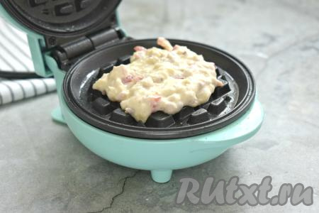 Разогреваем электрическую вафельницу, предварительно смазав панели растительным маслом. Выкладываем в центр нижней панели примерно 1,5 столовых ложки теста.