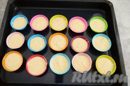 Силиконовые формочки заранее установить на противне. В каждую формочку выложить тесто, заполняя формочки на 3/4 объёма.