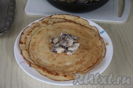 Начинку разделить на 10 частей (по количеству блинов). Выложить одну часть начинки на серединку блина.