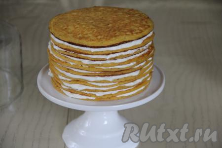 Сформировать торт, смазывая кремом каждый тыквенный блин и складывая блинчики друг на друга. Немного крема оставить для покрытия верха блинного торта.