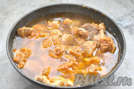 Затем вливаем в сковороду со свининой и луком примерно 300 миллилитров воды (мясо должно быть покрыто водой практически полностью), доводим до кипения.