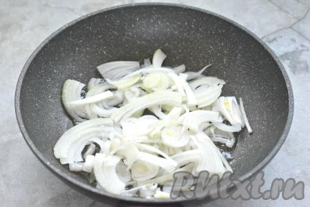 Репчатый лук очищаем, нарезаем полукольцами (или четверть кольцами). Разогреваем в глубокой сковороде растительное масло, выкладываем нарезанный лук, обжариваем его, иногда перемешивая, до мягкости (примерно 3-4 минуты).