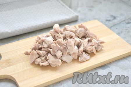 Варёное куриное мясо, отделив от костей (у меня получилось грамм 200 варёного куриного мяса без костей), нарезаем на небольшие кубики, выкладываем их в миску.