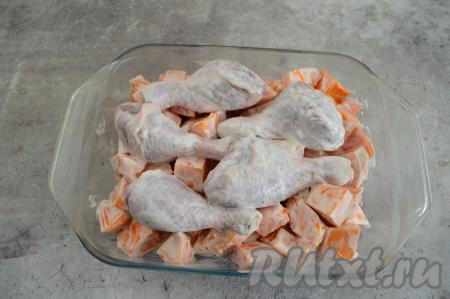 Поверх тыквы выложить куриные ножки. Отправить форму в духовку, разогретую до 200 градусов, на 40 минут. Затем вынуть форму из духовки, перемешать кусочки тыквы, куриные ножки перевернуть на другой бок.