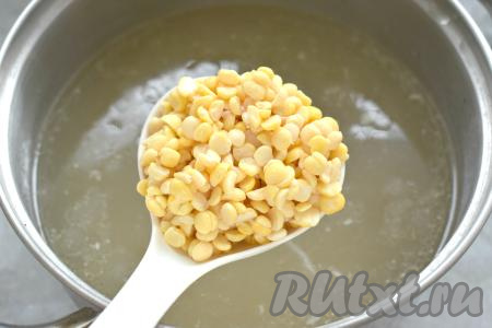 Затем варёное куриное мясо достаём из бульона. Даём мясу слегка остыть, отделяем его от костей, нарезаем на кусочки. Бульон, если нужно, процеживаем. В кастрюлю с бульоном добавляем нарезанное мясо курицы. Замоченный горох промываем, сливаем с него воду, выкладываем в кастрюлю с бульоном и мясом. Ставим на сильный огонь, после закипания варим на небольшом огне до мягкости гороха. Обычно на варку предварительно замоченного колотого гороха требуется минут 30, если у вас целый, предварительно замоченный горох, варить его придётся немного дольше.