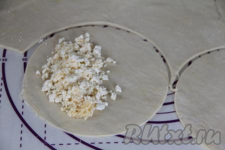 Начинку разделить на равные части (по количеству раскатанных кругов). Я разделила творожно-сырную начинку на 8 частей. На одну половину кружка из теста, отступив от края круга, выложить одну часть начинки (я выкладывала примерно 2 столовых ложки начинки).