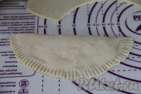 Тщательно скрепить края чебурека. Края чебурека я хорошо прижала вилкой, сформировав фигурный край. Постепенно сформировать все чебуреки.