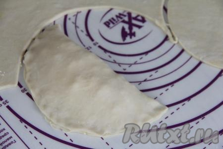 Чистым краем круга накрыть сторону круга с начинкой, формируя чебурек с творогом и сыром.