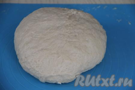 Вмесить масло в тесто. Переложить тесто на рабочую поверхность, припылённую мукой, и вымесить руками в течение 7-10 минут (до гладкого и мягкого состояния). Тесто должно практически не липнуть к рукам.