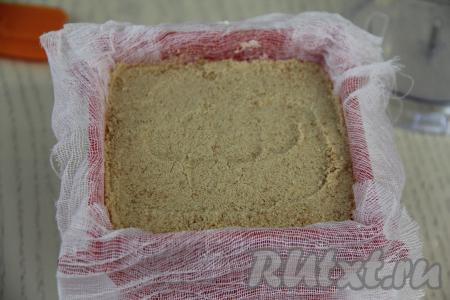 Выложить крошку из печенья поверх творожно-заварной массы, слегка утрамбовать. Аккуратно смочить поверхность печенья 50 миллилитрами сливок.