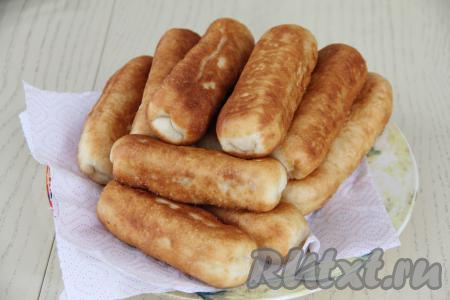 Готовые пирожки перекладывать со сковороды на бумажное полотенце, чтобы убрать излишки масла. В несколько приёмов пожарить все пирожки, подливая по мере необходимости масло в сковороду.