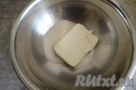 В миску выложить творог и сахар, растереть вилкой до однородности.