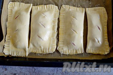 В небольшой ёмкости взбить яйцо вилкой до однородности. Для того чтобы готовая выпечка получилась более аппетитной, смазать каждую заготовку слойки взбитым яйцом.