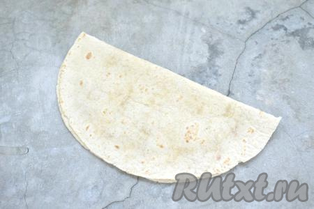 Накрываем начинку из фарша свободной стороной тортильи, края плотно прижимаем.