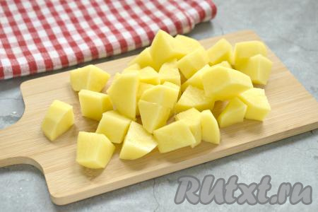 Пока капуста обжаривается, в кастрюле доводим до кипения 1,5-2 литра воды. В закипевшую воду выкладываем очищенную и нарезанную на небольшие кубики картошку, ещё раз даём воде закипеть. А затем варим картофель на небольшом огне 15 минут.